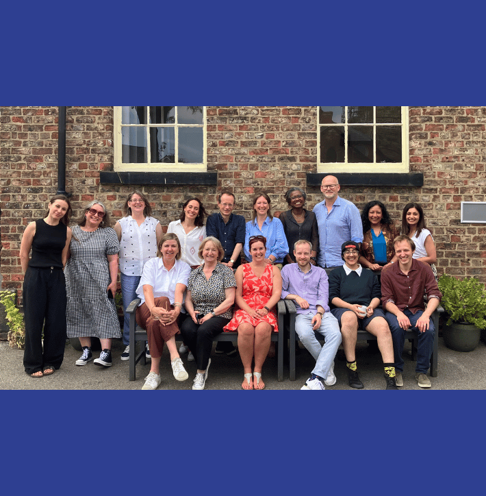 Friends Provident Foundation staff and trustees sat on and around a bench in the sunshine.
