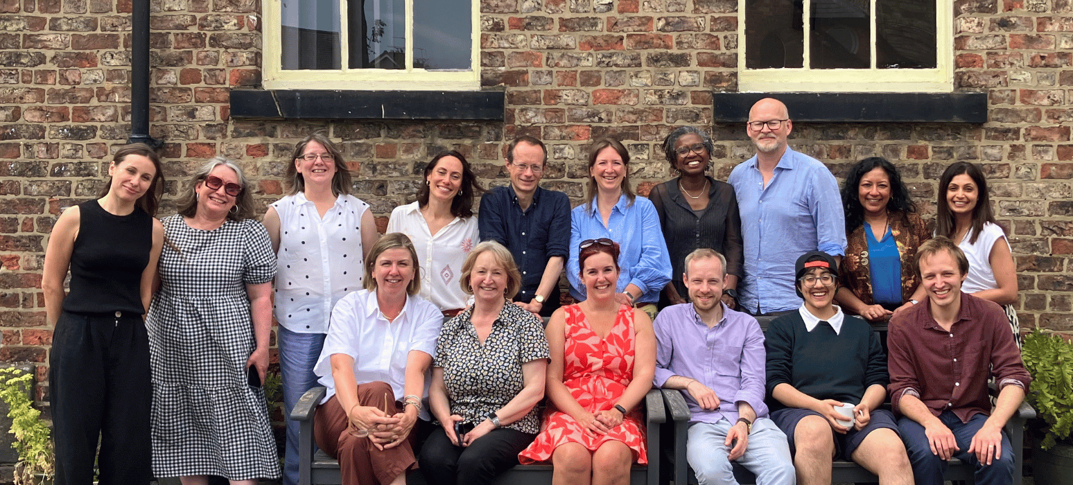 Friends Provident Foundation staff and trustees sat on and around a bench in the sunshine.