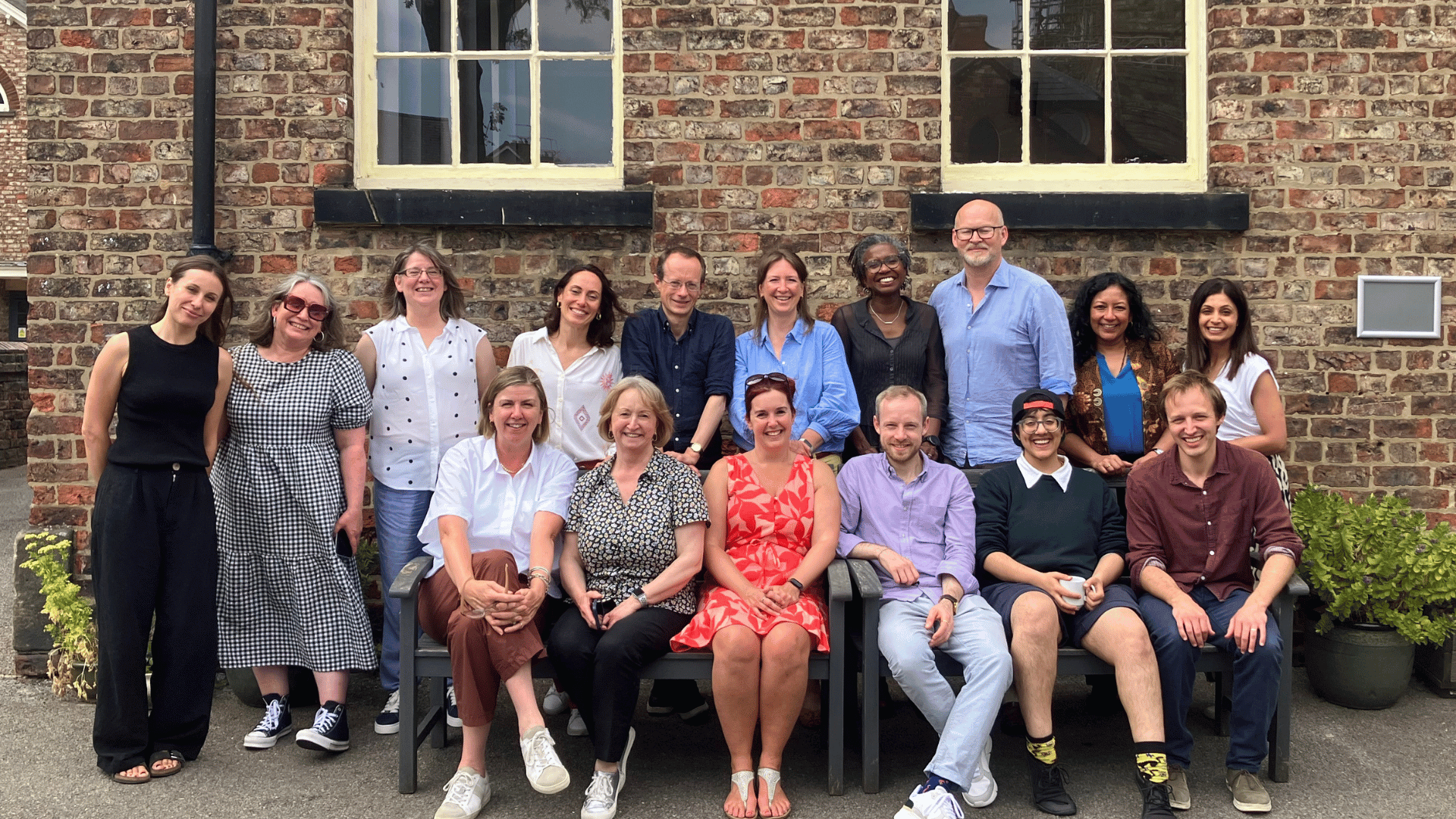 Friends Provident Foundation staff and trustees sat on and around a bench in the sunshine.